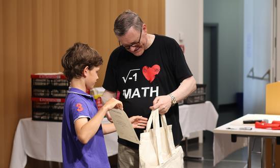 Ein Schüler erhält eine Urkunde und Preise