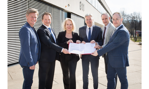 Rektorin, Rektoren, Geschäftsführer der Fachhochschule Kärnten und Landeshauptmann Kaiser blicken in die Kamera und haltn die Kooperationsvereinbarung