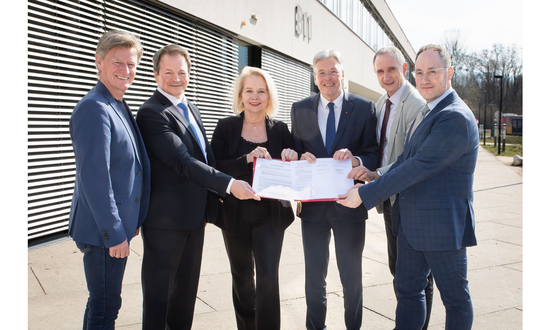 Rektorin, Rektoren, Geschäftsführer der Fachhochschule Kärnten und Landeshauptmann Kaiser blicken in die Kamera und haltn die Kooperationsvereinbarung