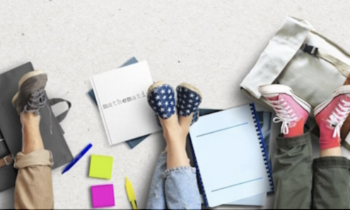 Beine von am Boden sitzenden Studierenden mit Studienunterlagen