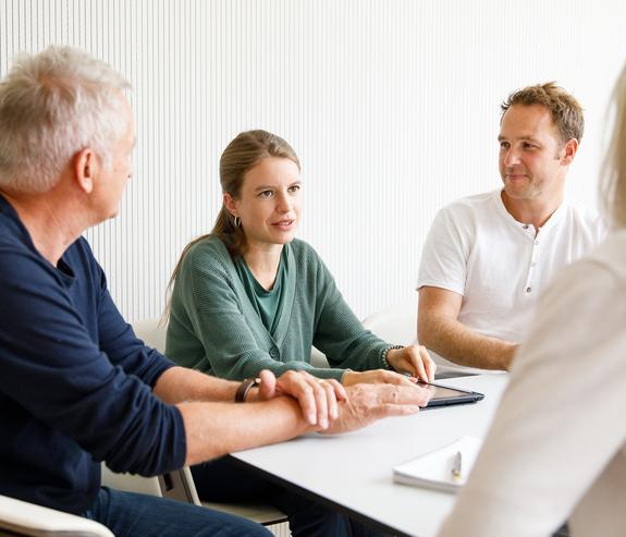 Drei Personen unterhalten sich an einem Tisch