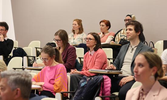 Eine Grupper junger Menschen sitzt in einem Hörsaal und blickt gespannt nach vorne