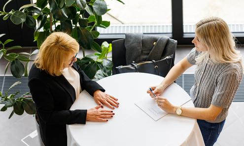2 Frauen bei einem Stehtisch stehend 
