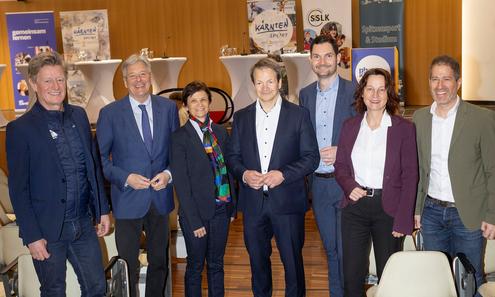 Frauen und Männer der Pressekonferenz schauen stehend in die Kamera