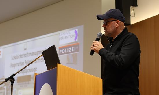 Vortragender am Pult mit Mikrofon