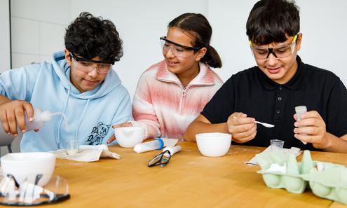 1 Schülerin und 2 Schüler experimentieren