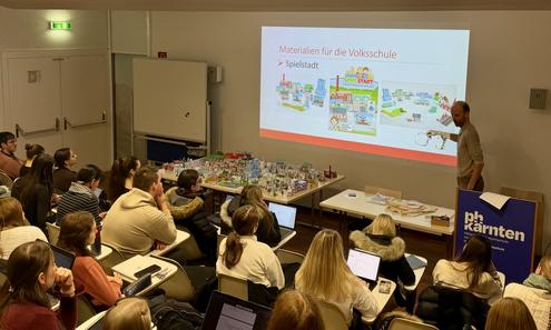 Blick von hinten in einem gefüllten Hörsaal auf die Bühne