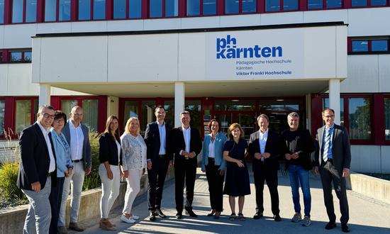Männer und Frauen stehen vor dem Eingang der PH Kärnten
