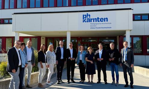 Männer und Frauen stehen vor dem Eingang der PH Kärnten
