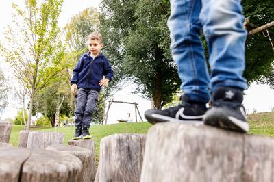 Kinder beim Balancieren über Holzstapfel
