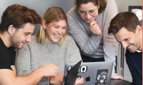 2 Frauen und 2 Männer schauen gemeinsam auf Desktop eines Laptops