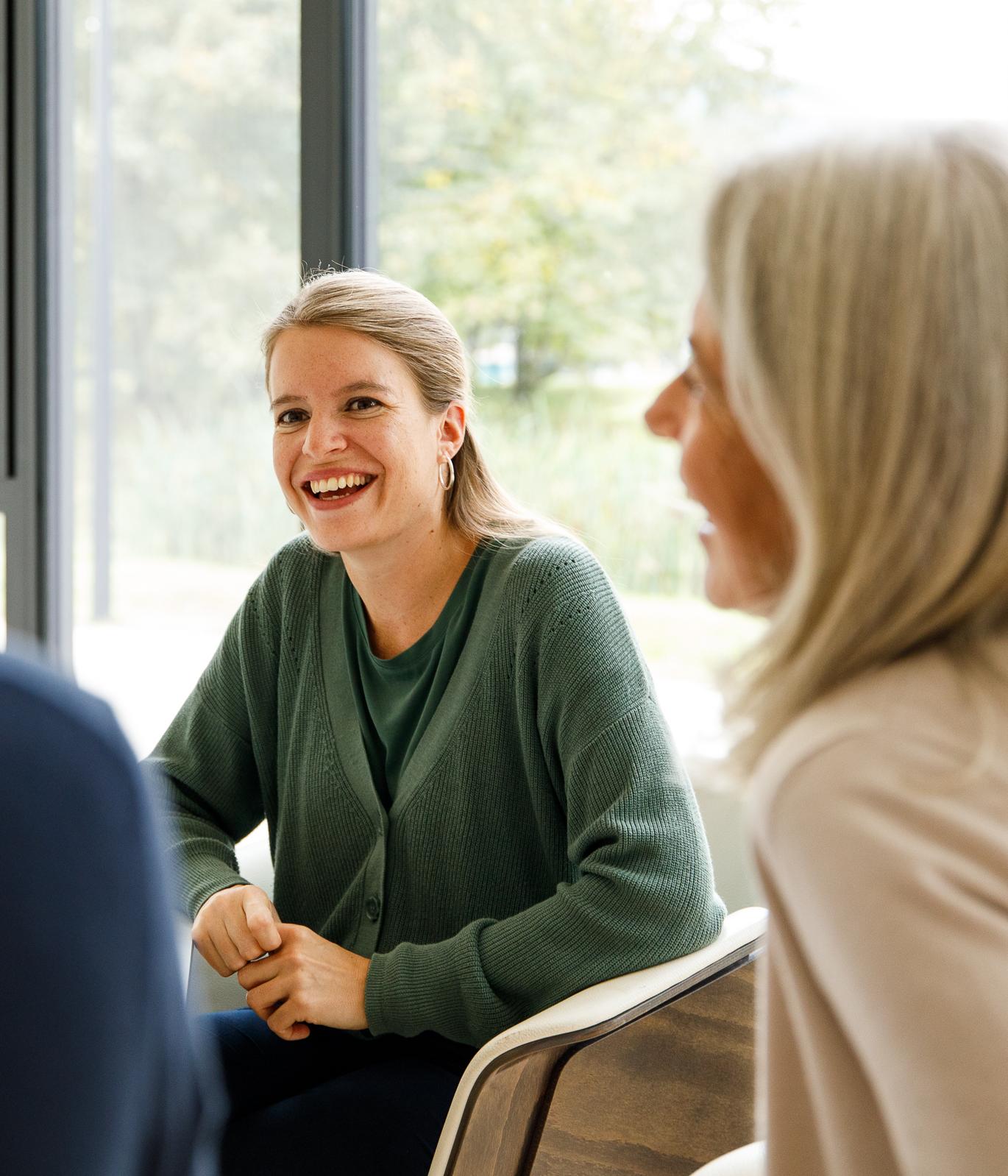 Zwei Frauen lächelnd in einem Beratungsgespräch