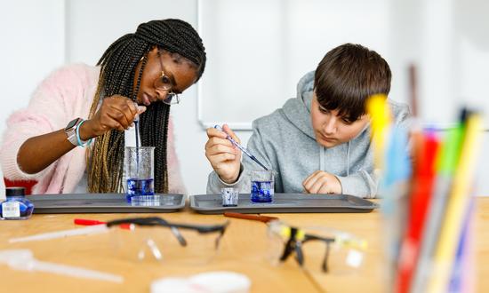Eine Schülerin und ein Schüler bei der praktischen Arbeit im naturwissenschaftlichen Unterricht