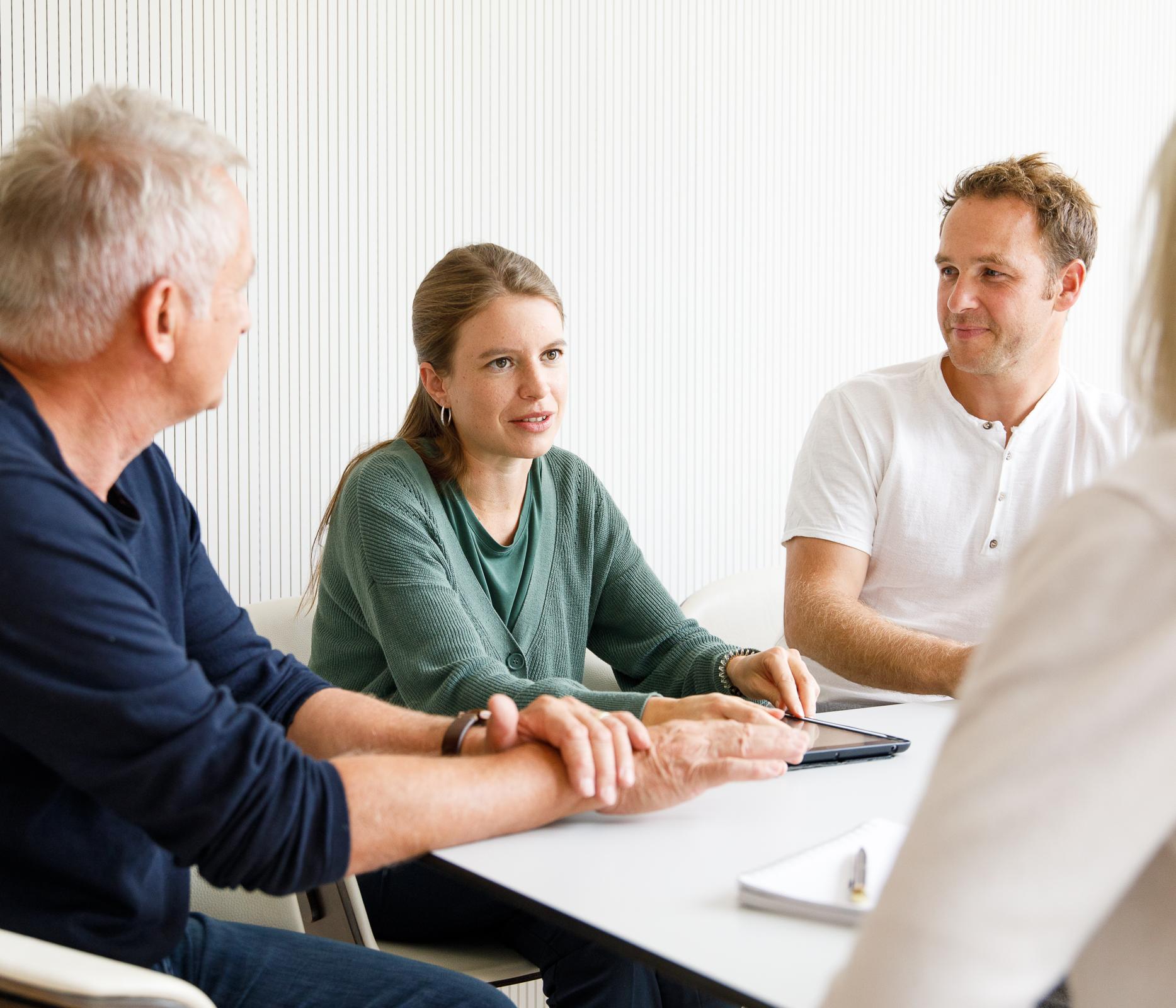 Drei Personen unterhalten sich an einem Tisch